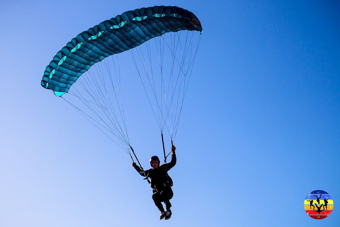 A man under a blue parachute