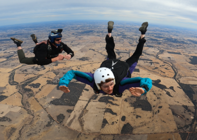AFF student in a stable freefall arch with an instructor over the Darkan landscape in Western Australia.