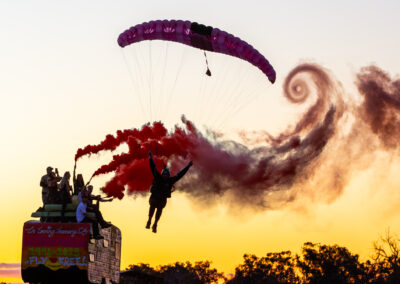 Skydiver under a pink parachute landing during the Mumble's skydiving boogie at Hillman Farm, Darkan, Western Australia.