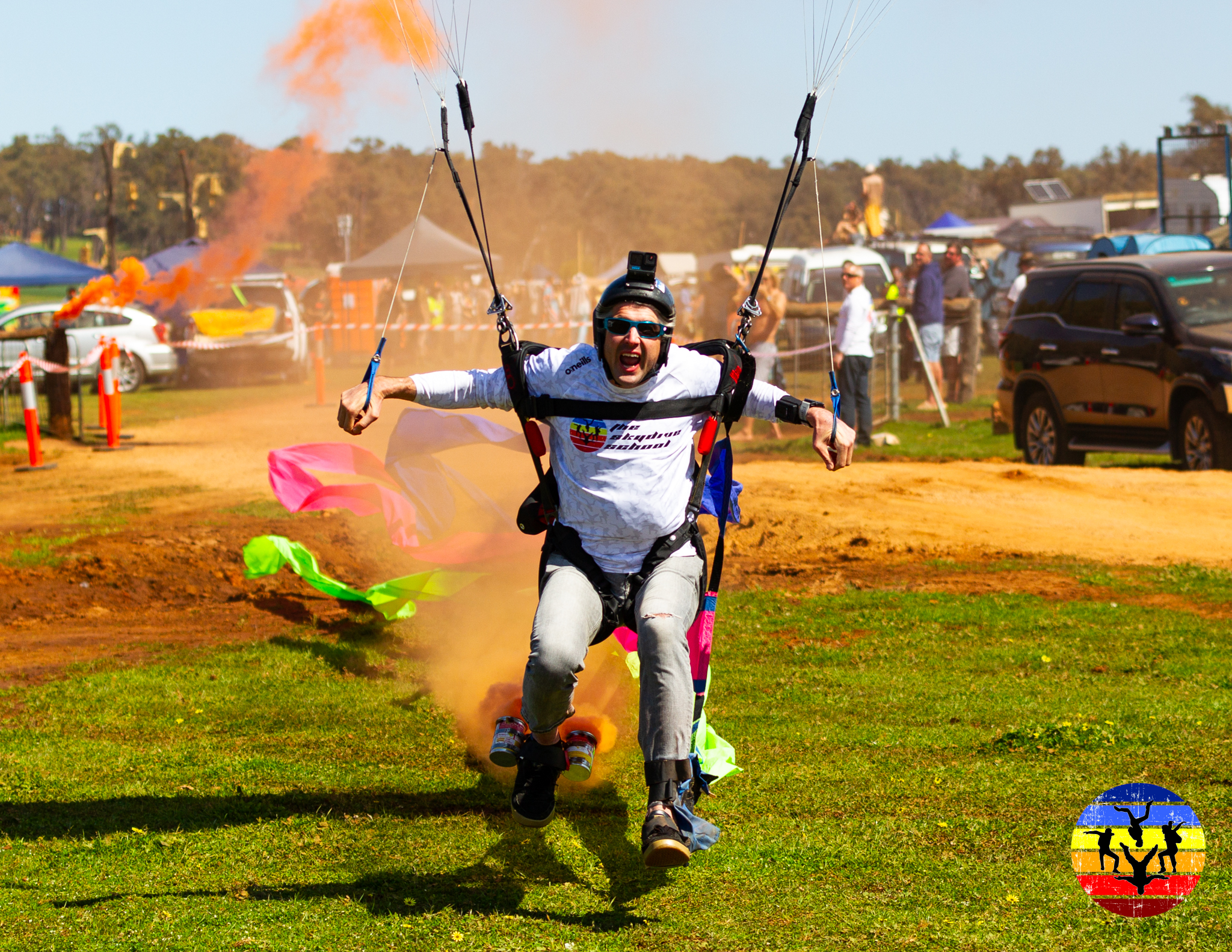 A Skydive School jumper landing with smoke and streamers at a festival display jump in WA