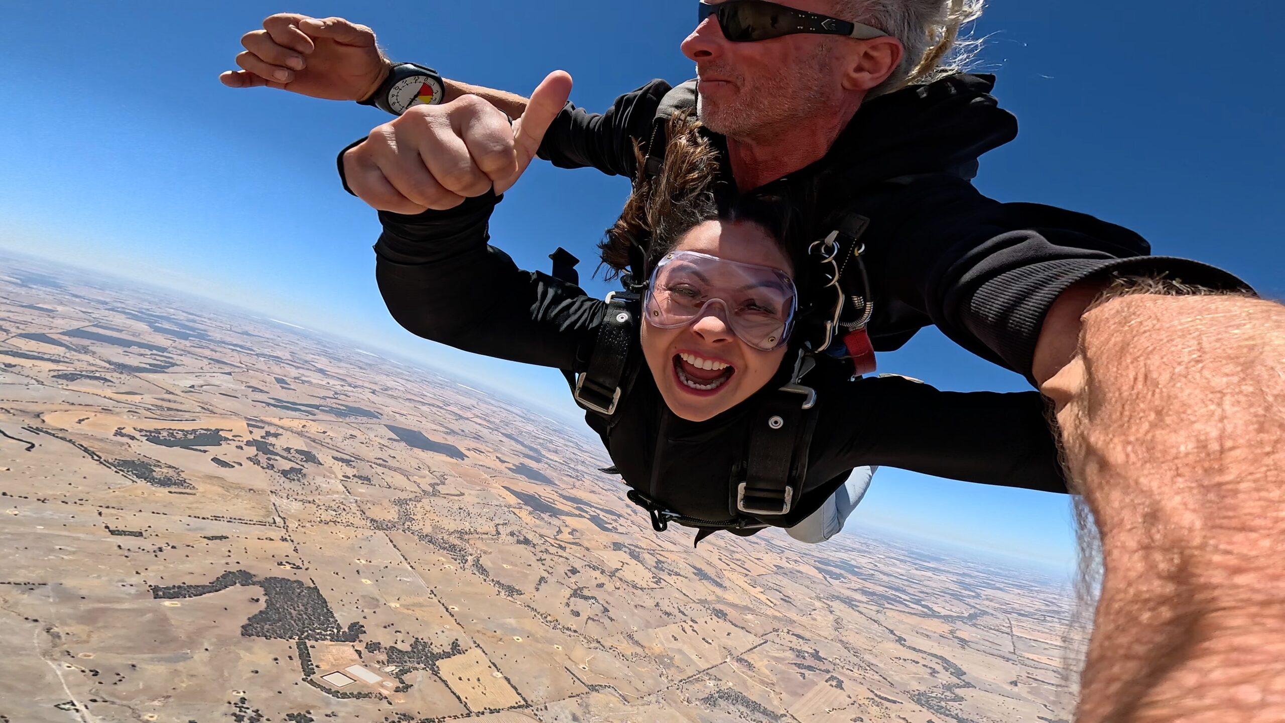 Young woman smiling in freefall during a tandem skydive over Darkan